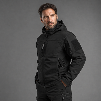 Man wearing black softshell jacket and utility trousers, half-body three-quarter studio view