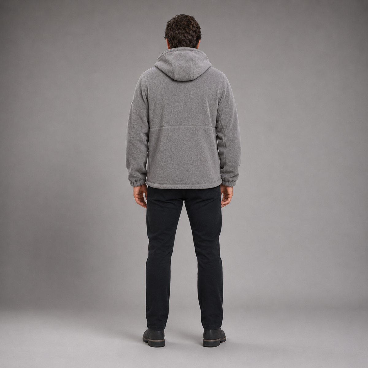 Man wearing gray thermal fleece jacket in full-body rear studio view